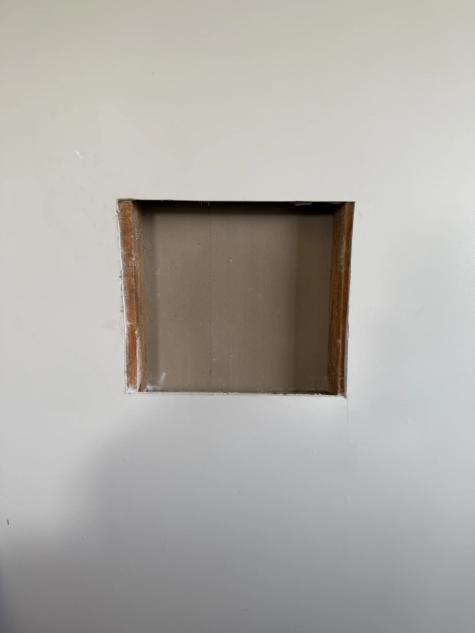 Hole cut back to a clean rectangle with studs visible