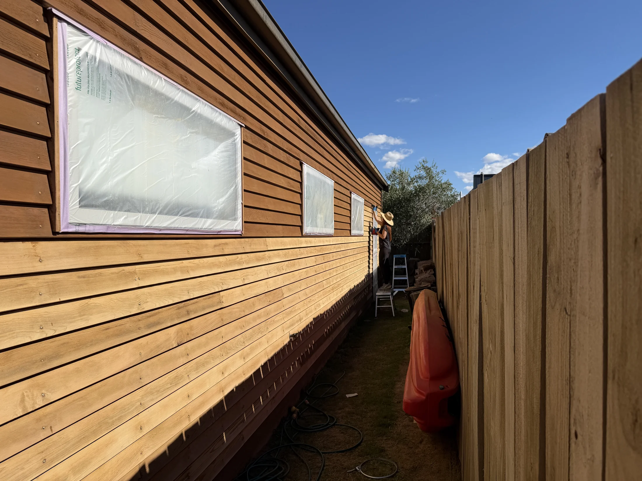 Staining cedar weatherboards in progress in Northlake, Wanaka